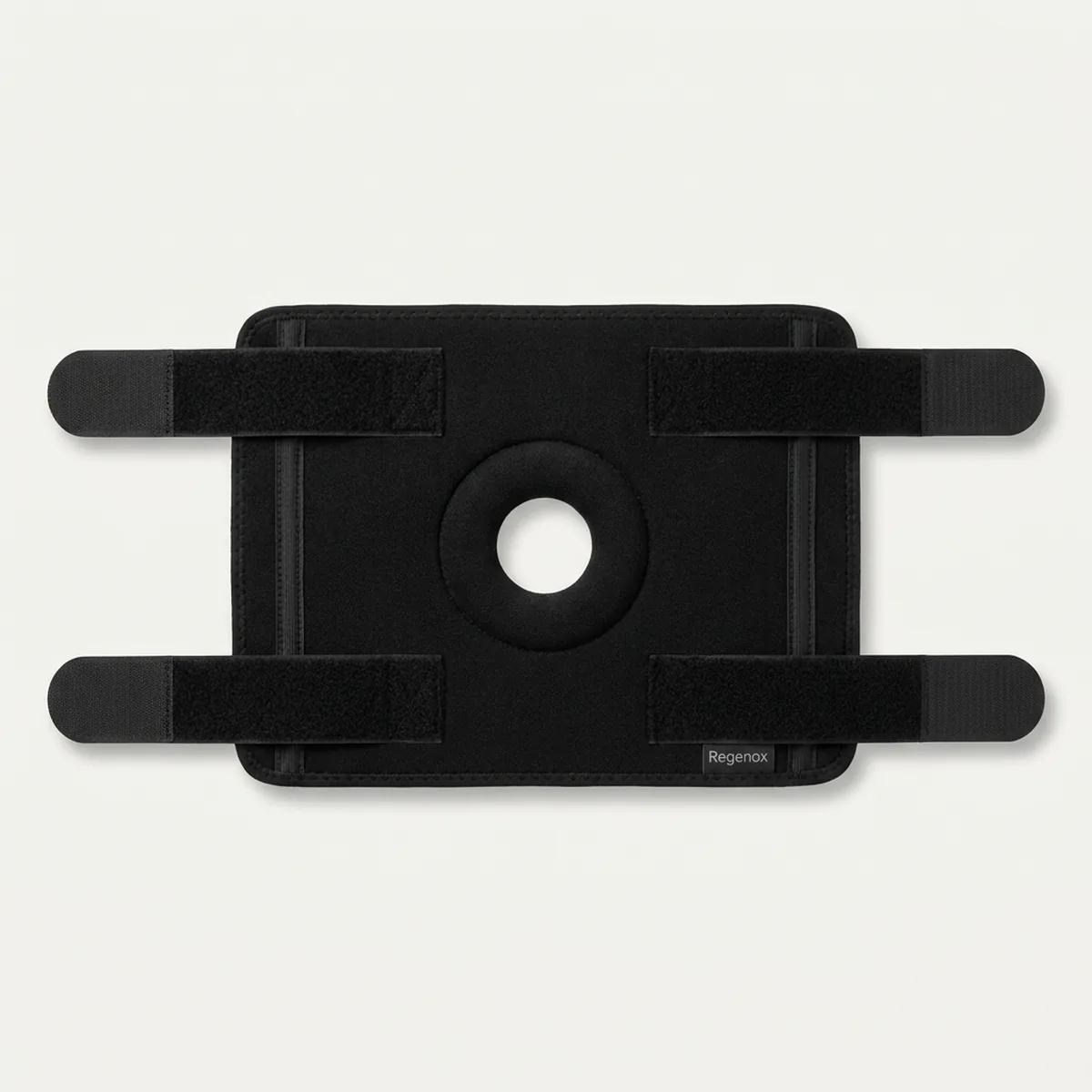 Black Regenox adjustable knee support laid flat, showing the four hook-and-loop straps and the open kneecap with padded ring